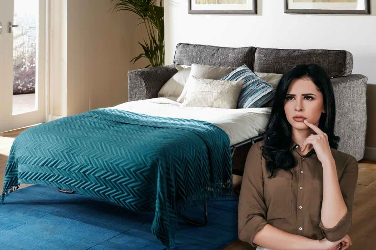 Donna pensierosa e sul fondo divano letto aperto