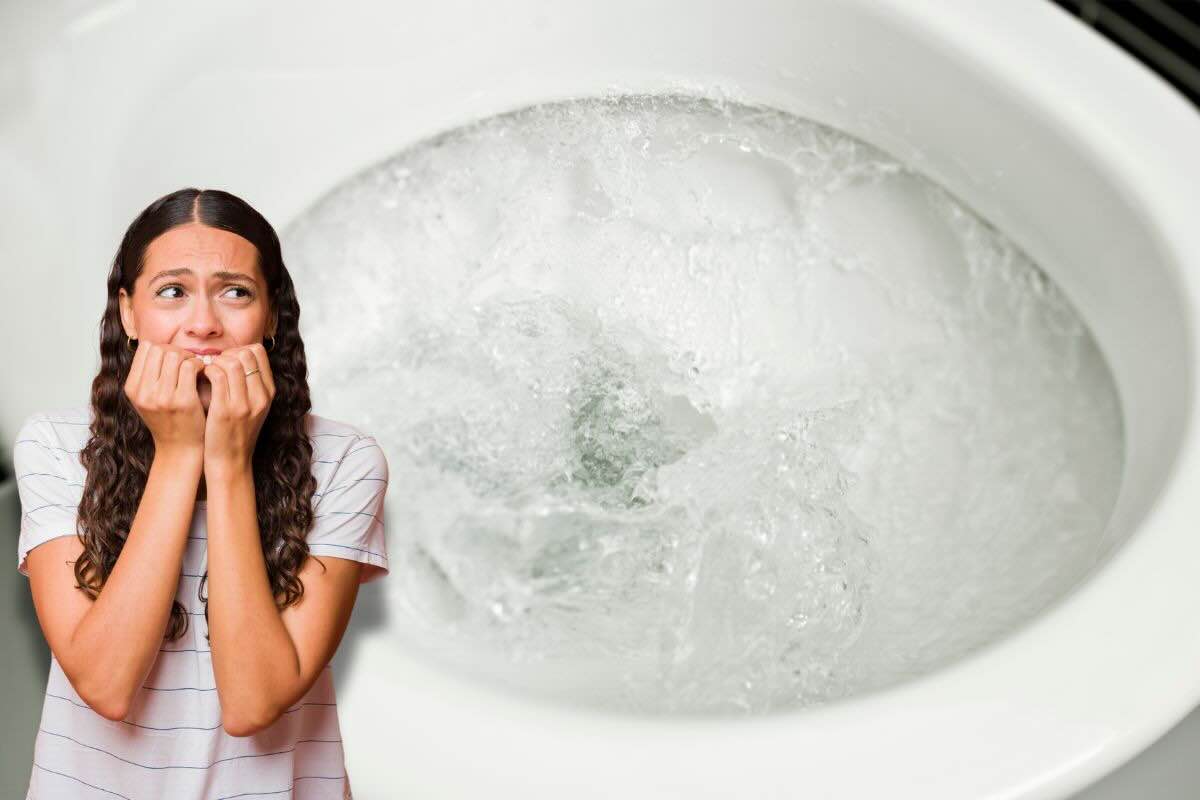 Donna spaventata, dietro di lei scarico WC