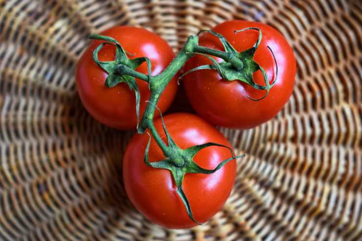tre pomodori rossi all'interno di una cesta