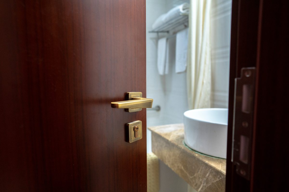 porta di un bagno che si apre e si intravede un lavandino
