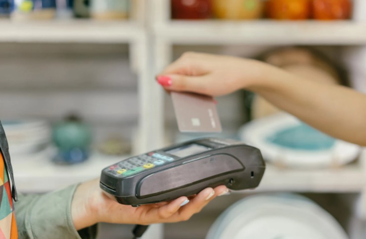 donna che appoggia il bancomat sul pos per pagare