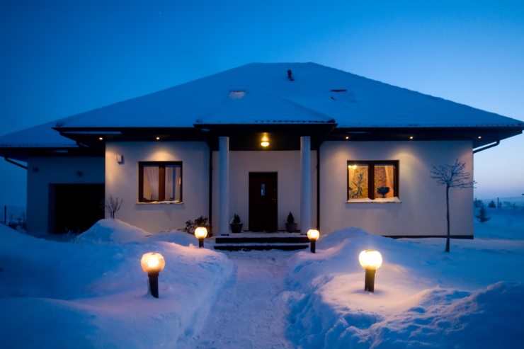 una casa in inverno circondata dalla neve