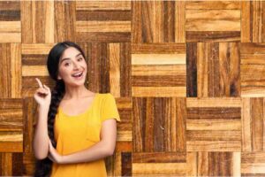 Ragazza sorridente con dito alzato, sul fondo parquet graffiato