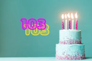 torta di compleanno con le candeline e accanto il numero 103