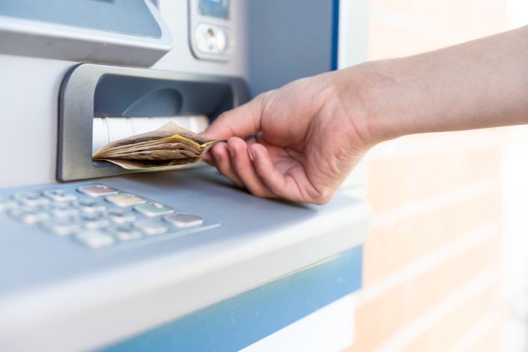 una persona che preleva dei soldi dal Bancomat