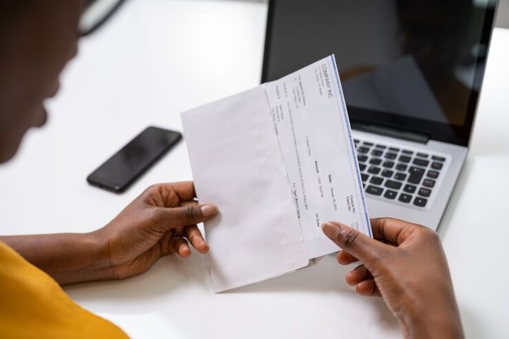 Mani tengono lettera davanti al PC e lo leggono