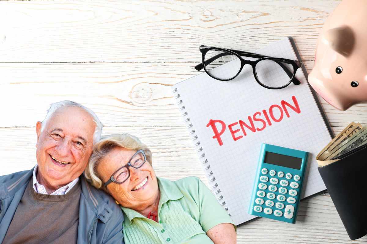 due persone anziane e un quaderno dove c'è scritto pensione sopra con occhiali e calcolatrice