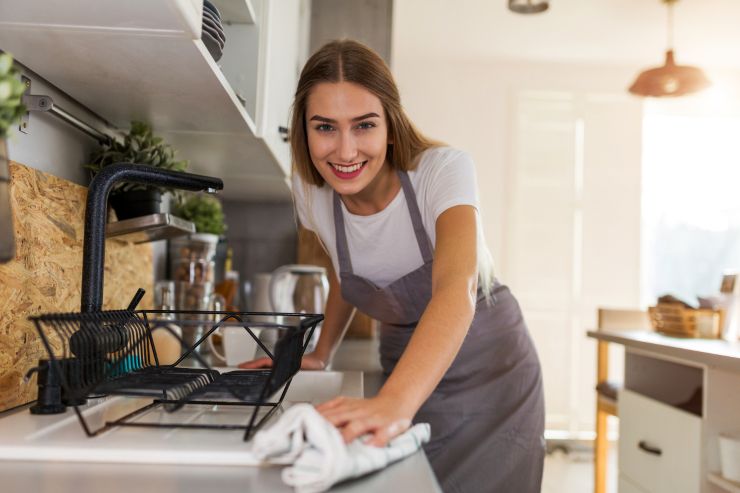 ragazza felice con un panno in mano che ha lavato la cucina