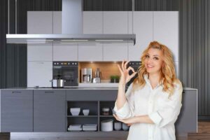 Donna fa ok con la mano, sul fondo la cucina