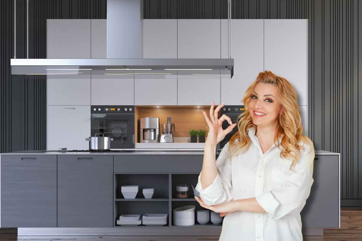 Donna fa ok con la mano, sul fondo la cucina