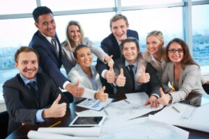 colleghi in ufficio felici con i pollici verso l'alto che sorridono