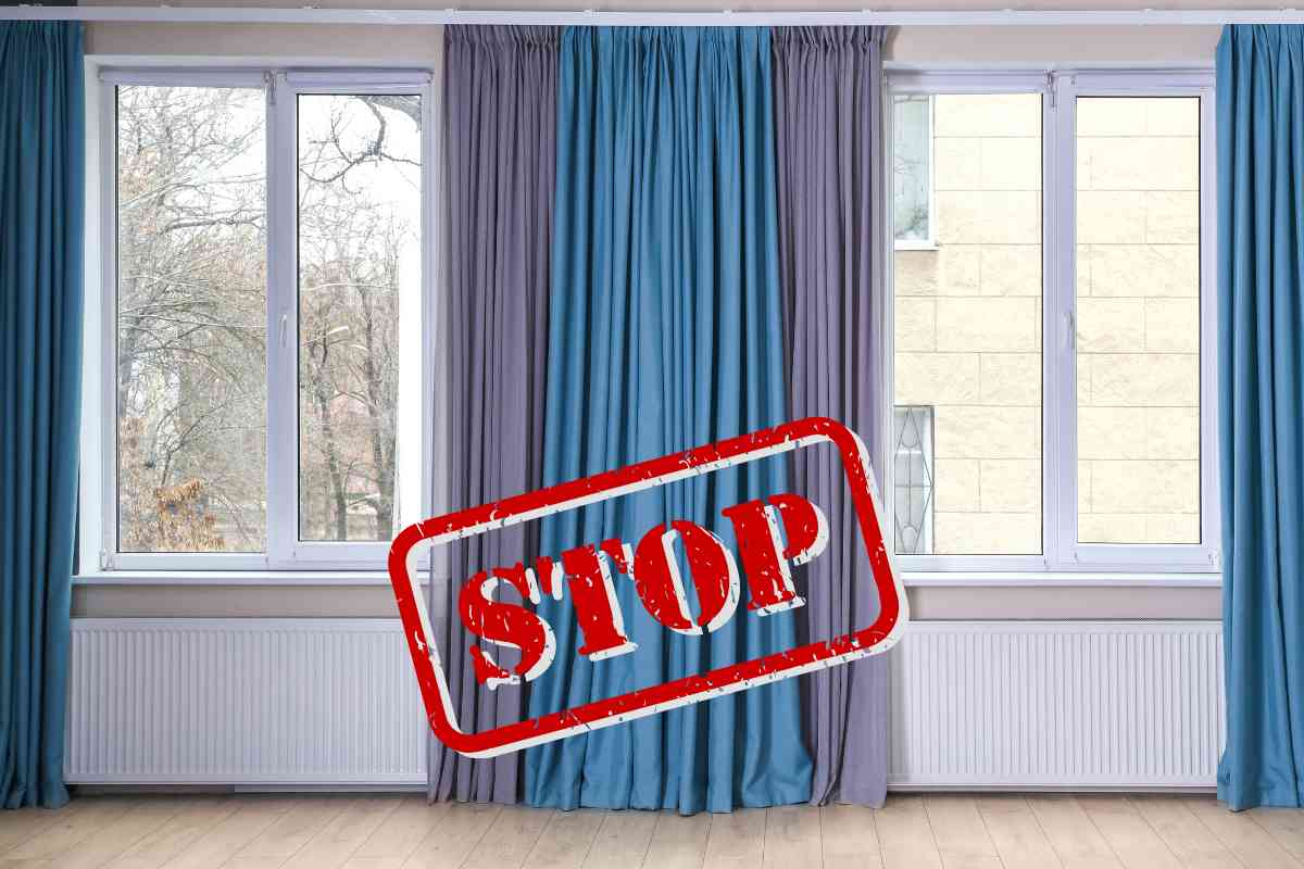 finestre con le tende con davanti una scritta in rosso "STOP"