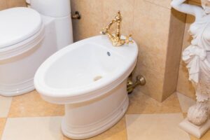 bidet bianco con rubinetto oro