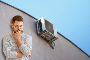 Uomo pensieroso, sulla parete esterna installato il condizionatore