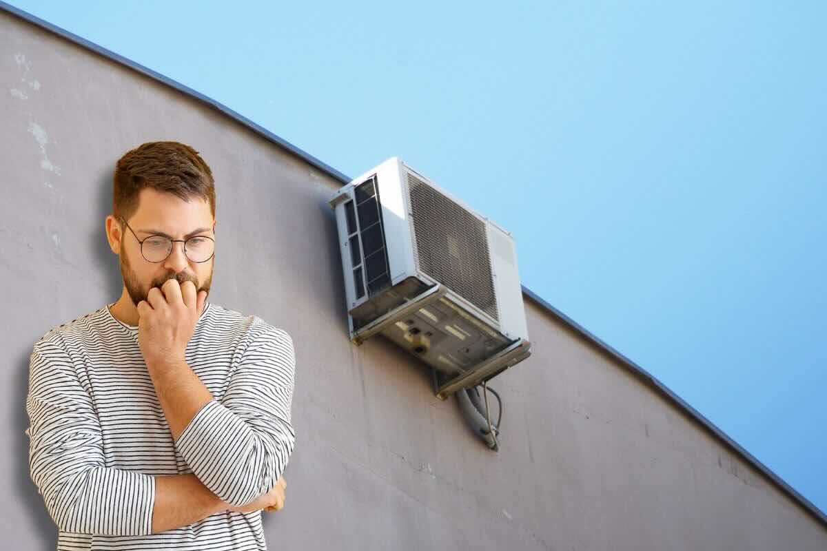 Uomo pensieroso, sulla parete esterna installato il condizionatore
