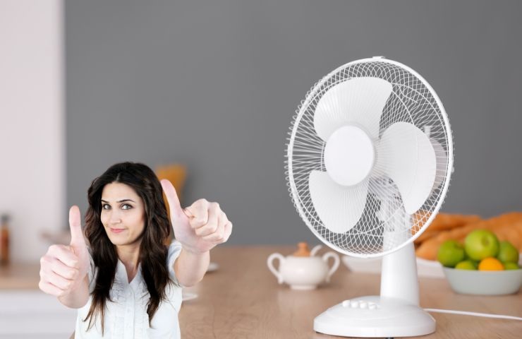 un ventilatore su un tavolo e la ragazza che fa ok