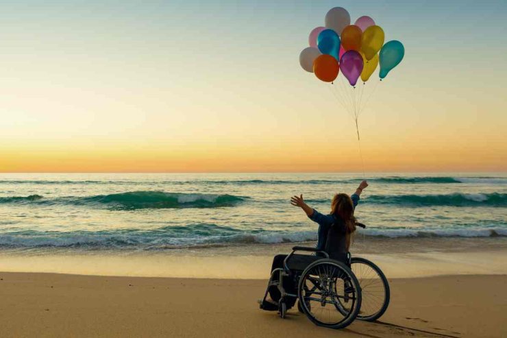 Persona in spiaggia con palloncini