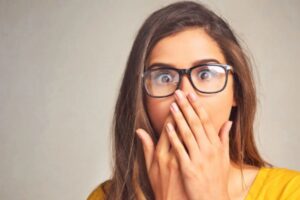 donna sconvolta con le mani davanti alla bocca