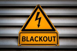 una saracinesca abbassata abbassata con sopra un cartello che segnala un "Blackout"