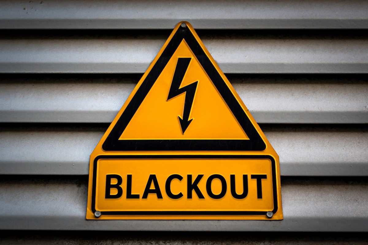 una saracinesca abbassata abbassata con sopra un cartello che segnala un "Blackout"