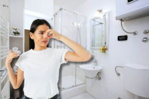 Donna si tappa naso, bagno sullo sfondo