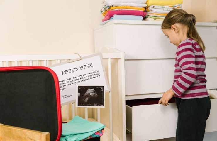 una bambina ed accanto un foglio con la notifica dello sfratto