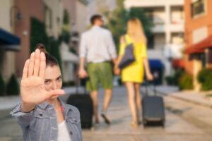 coppia che ritorna dalle vacanze e donna che fa stop con le mani