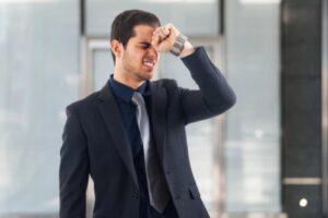 uomo d'affari disperato che appoggia un pugno sulla fronte