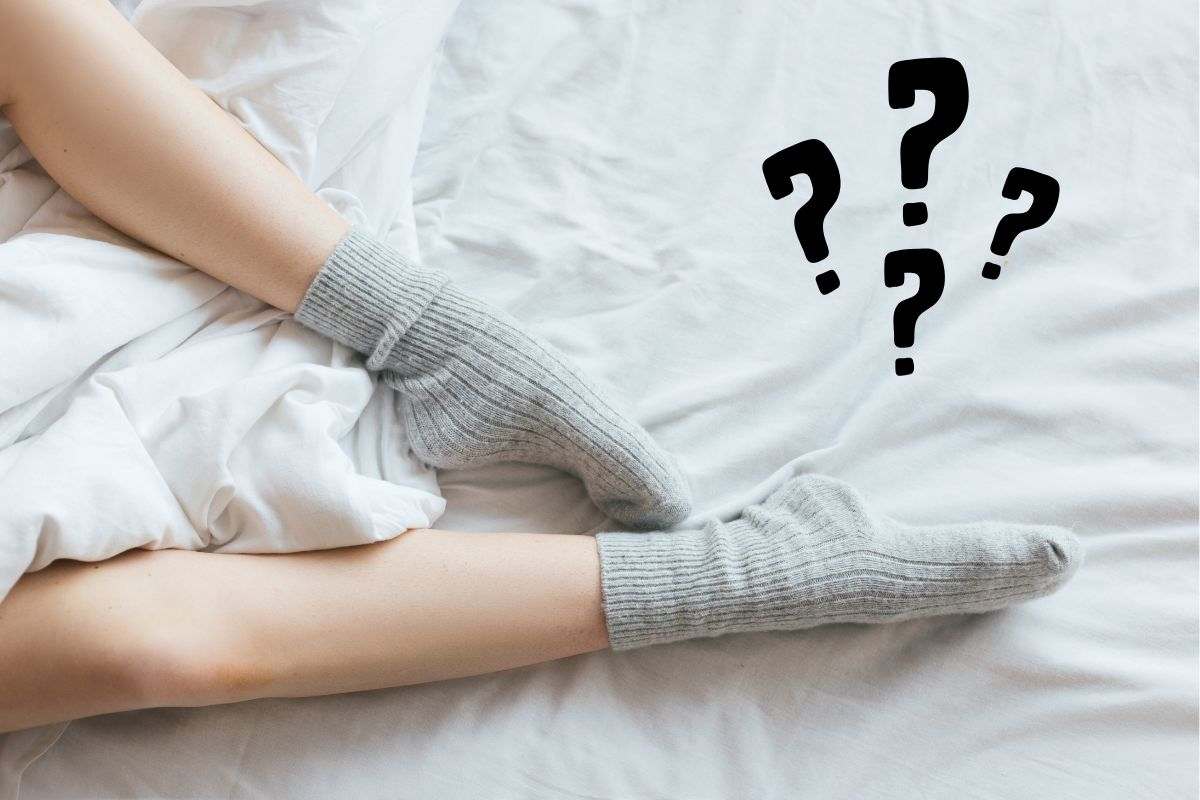 una ragazza con i calzini a letto e 4 punti interrogativi