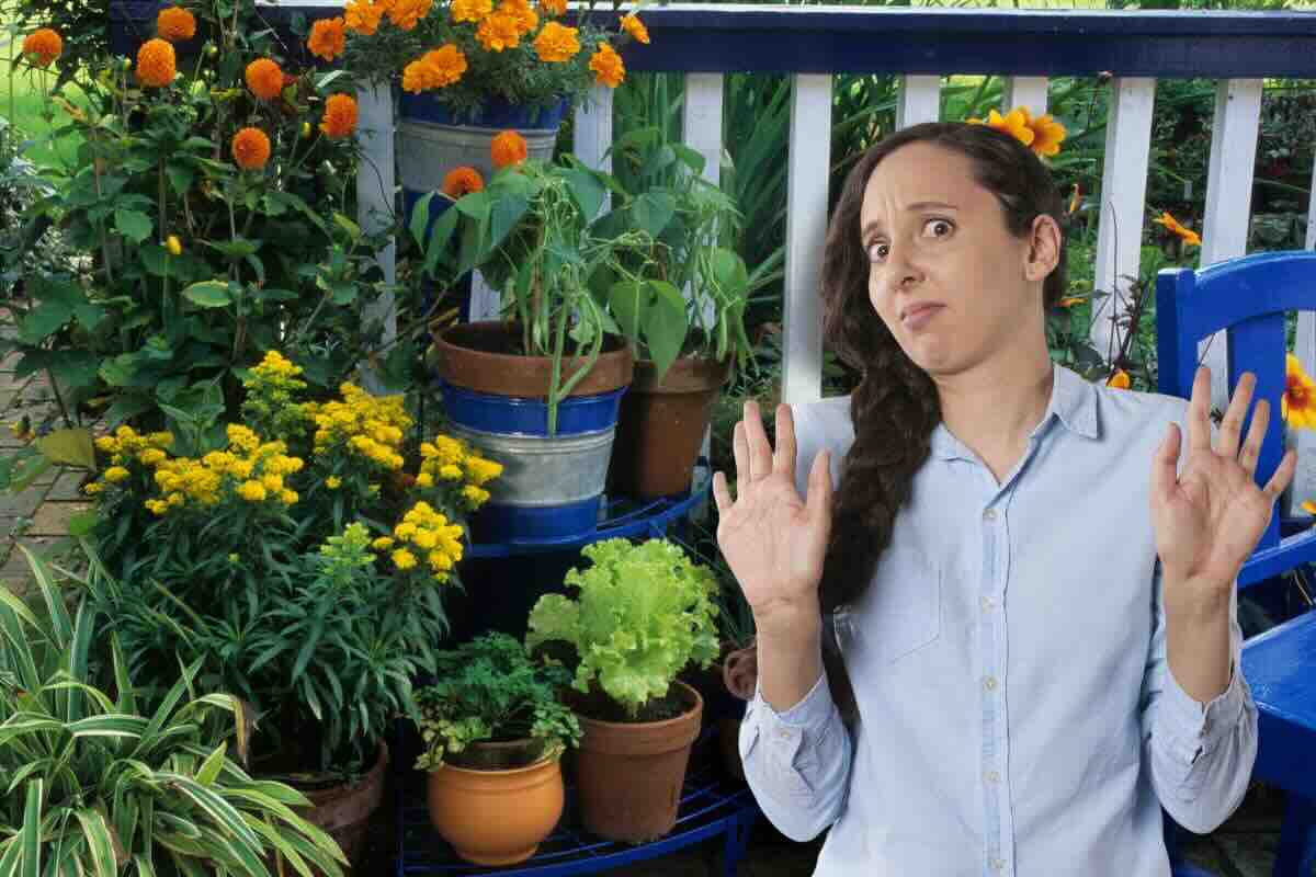 Donna contrariata mani alzate, piante in vasi nel balcone