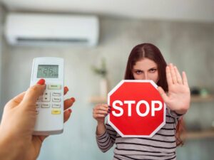 donna che accende aria condizionata e un'altra con cartello stop tra le mani