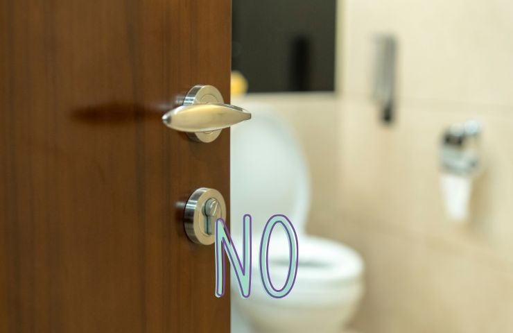 una porta del bagno aperta e la scritta no