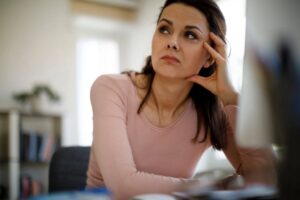 donna pensierosa seduta alla scrivania