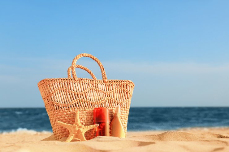 una foto di una borsa da mare in spiaggia con sfondo il mare