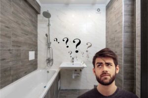 un bagno con le piastrelle e un ragazzo dubbioso