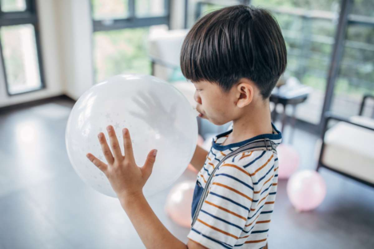 bambino gonfia palloncino