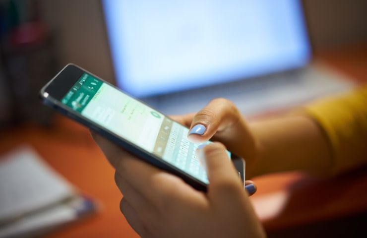 una persona legge messaggi su whatsapp