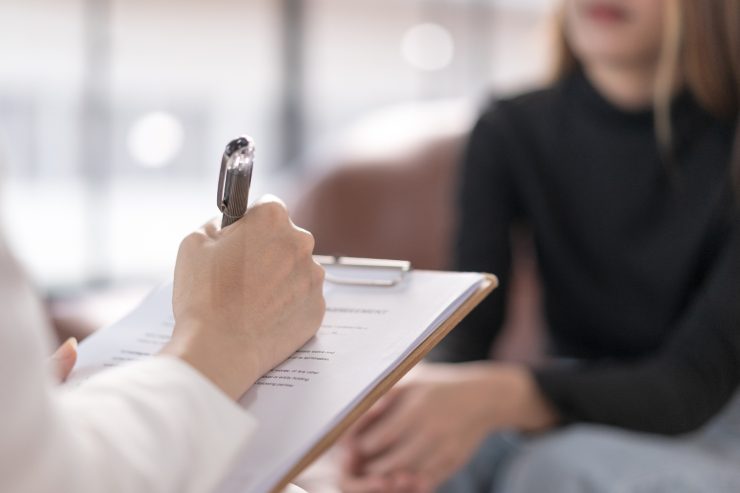 una psicologa che fa una seduta con una sua paziente e prende appunti