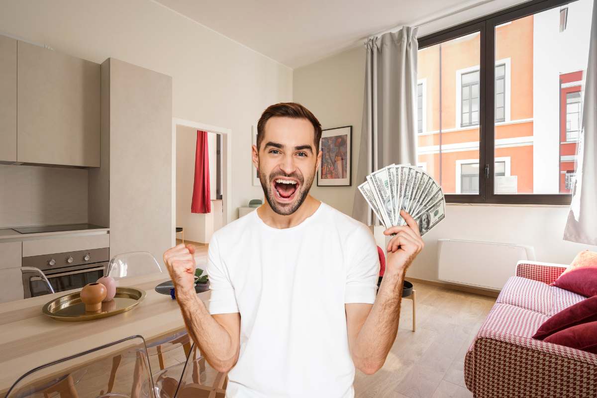 un salone di una casa con un uomo in primo piano che esulta con dei soldi in mano 